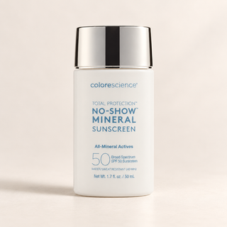 A white bottle of Colorescience No-Show Mineral Sunscreen with a reflective silver cap, set against a clean, warm off-white background.