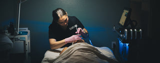 Facelogic esthetician using a handheld skincare device during a facial treatment