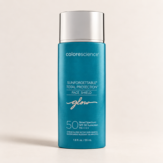 A bottle of Colorescience Sunforgettable Total Protection Face Shield SPF 50 sunscreen, featuring a vibrant teal blue bottle with a metallic silver cap, set against a clean, light beige background.